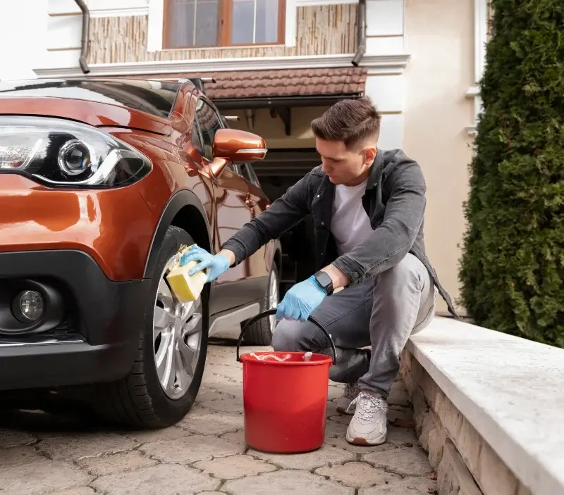 Lavage auto à domicile Corcelles-les-Arts : professionnel intervenant sur un véhicule